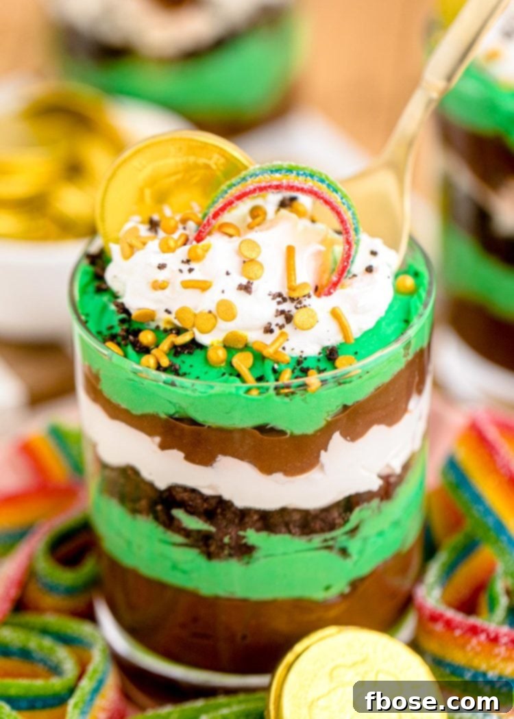 A spoon taking a bite out of a st patrick's day pudding parfait.