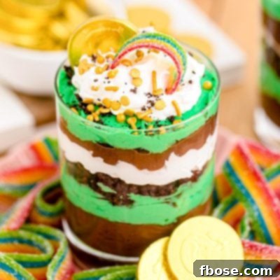 Close up photo of a St Patrick's Day Pudding and Oreo Dessert Cup on a plate with gummy rainbows.
