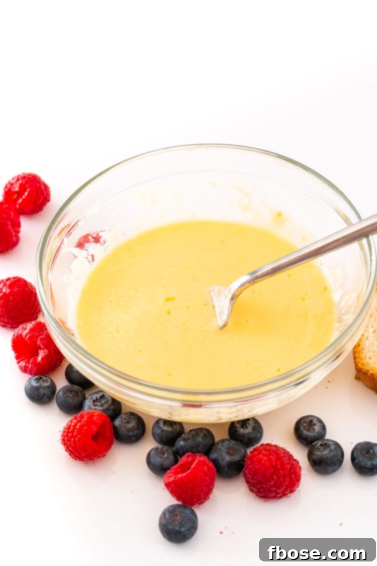 Yogurt Custard Toast 5 Yogurt toast filling whisked together in a glass mixing bowl with berries around it.