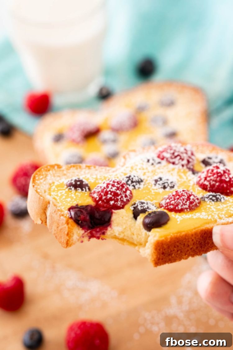 Yogurt Custard Toast 7 A woman's hand holding a slice of yogurt toast with a bite taken out of it to show the texture of the filling.