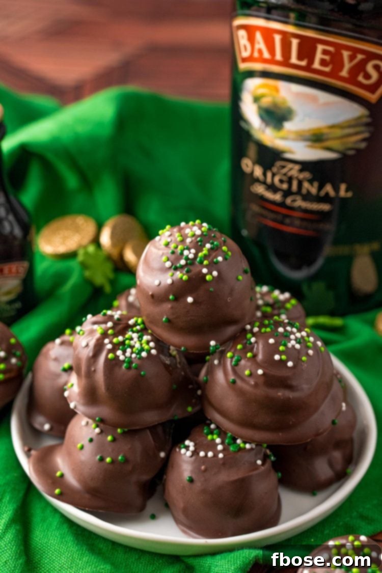 Close up photo of Bailey's Irish Cream Cheesecake Truffles on a white plate on a green napkin.