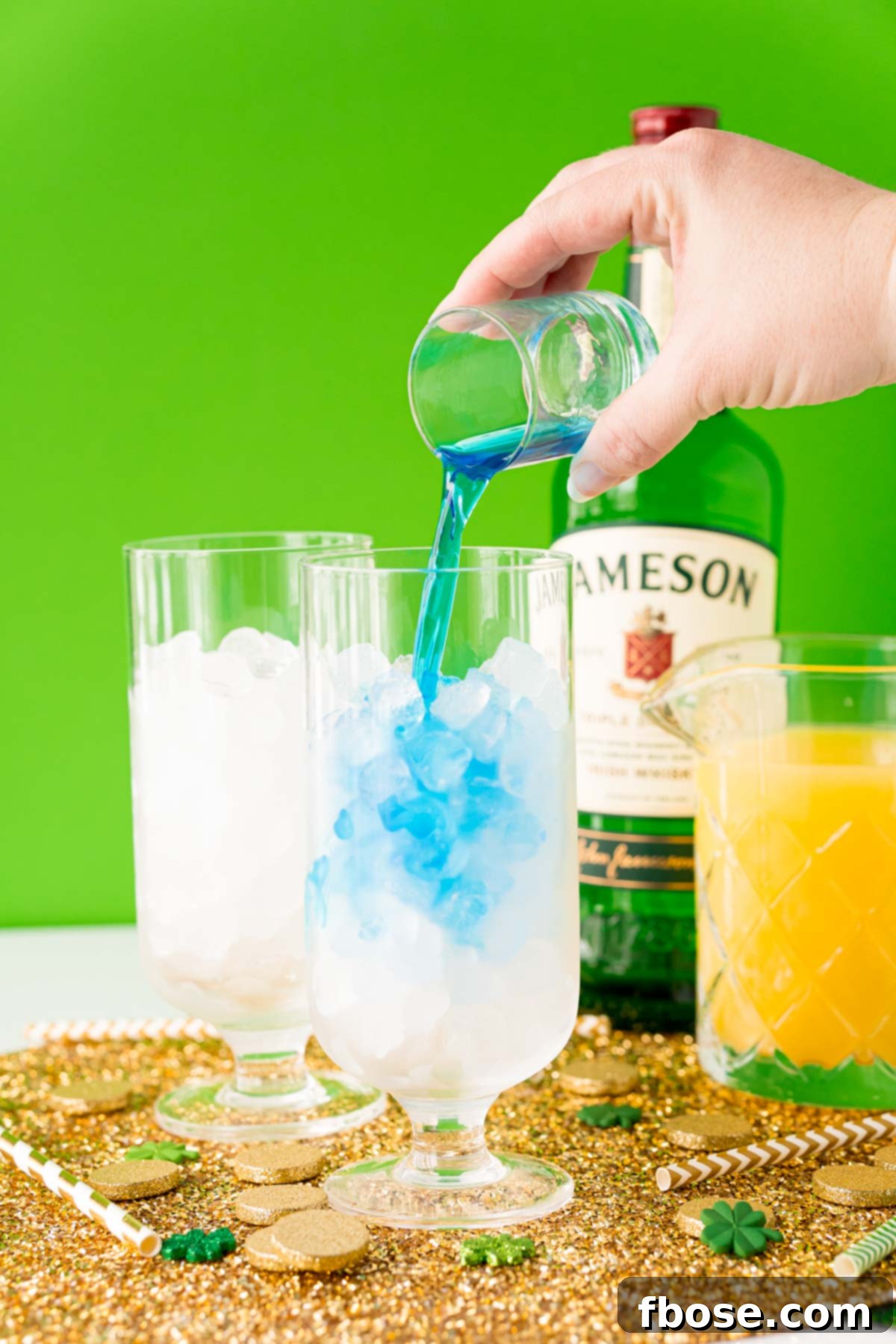 Jig Juice 5 Blue curacao being poured into a glass with ice.