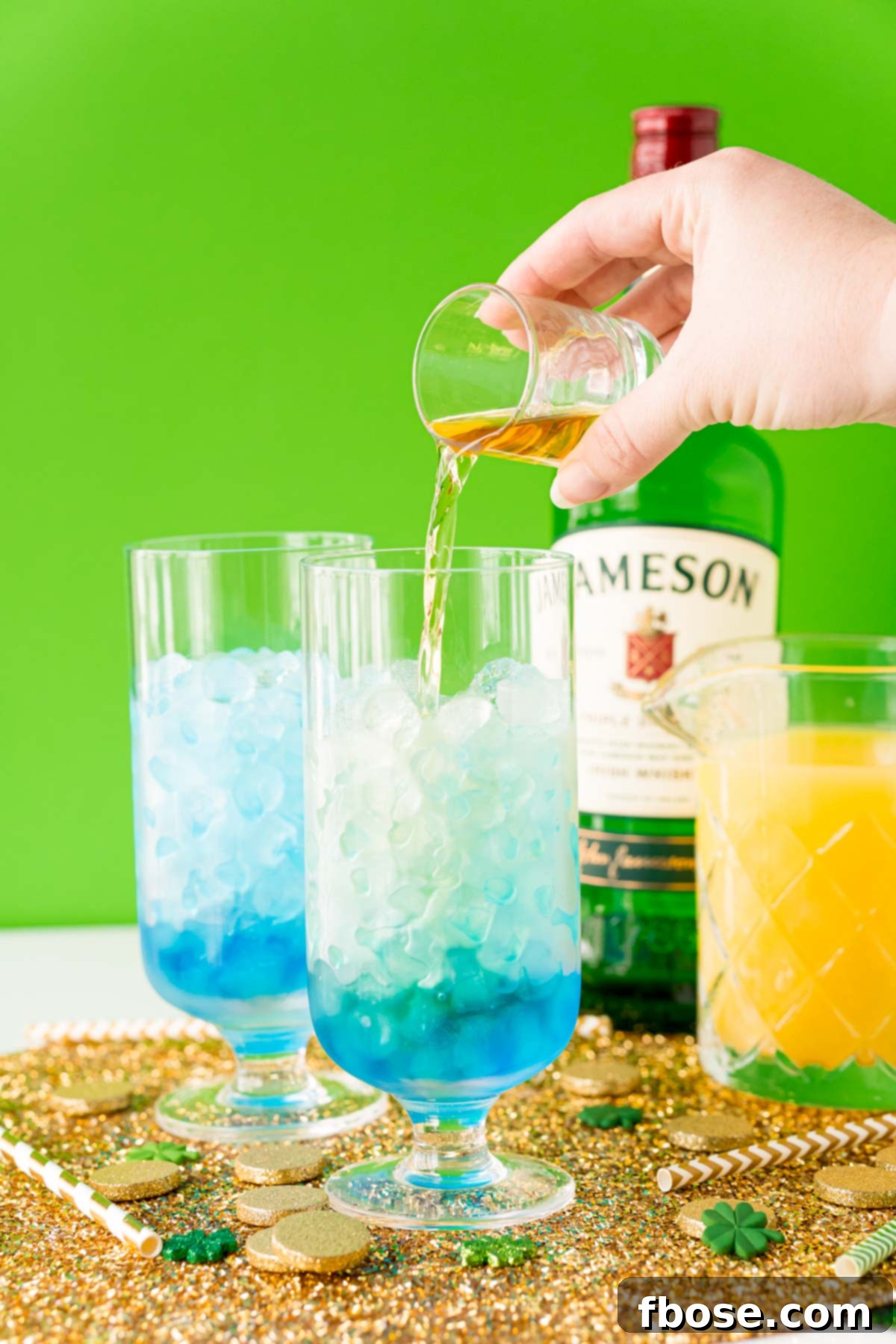 Jig Juice 6 Irish whiskey being poured into a glass with ice and blue curacao.