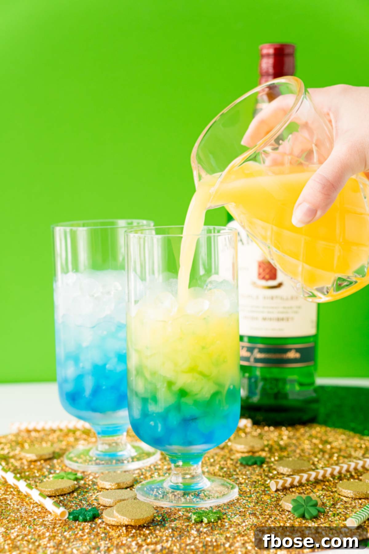 Jig Juice 7 Orange juice being poured into a cocktail glass with whiskey and blue curacao.
