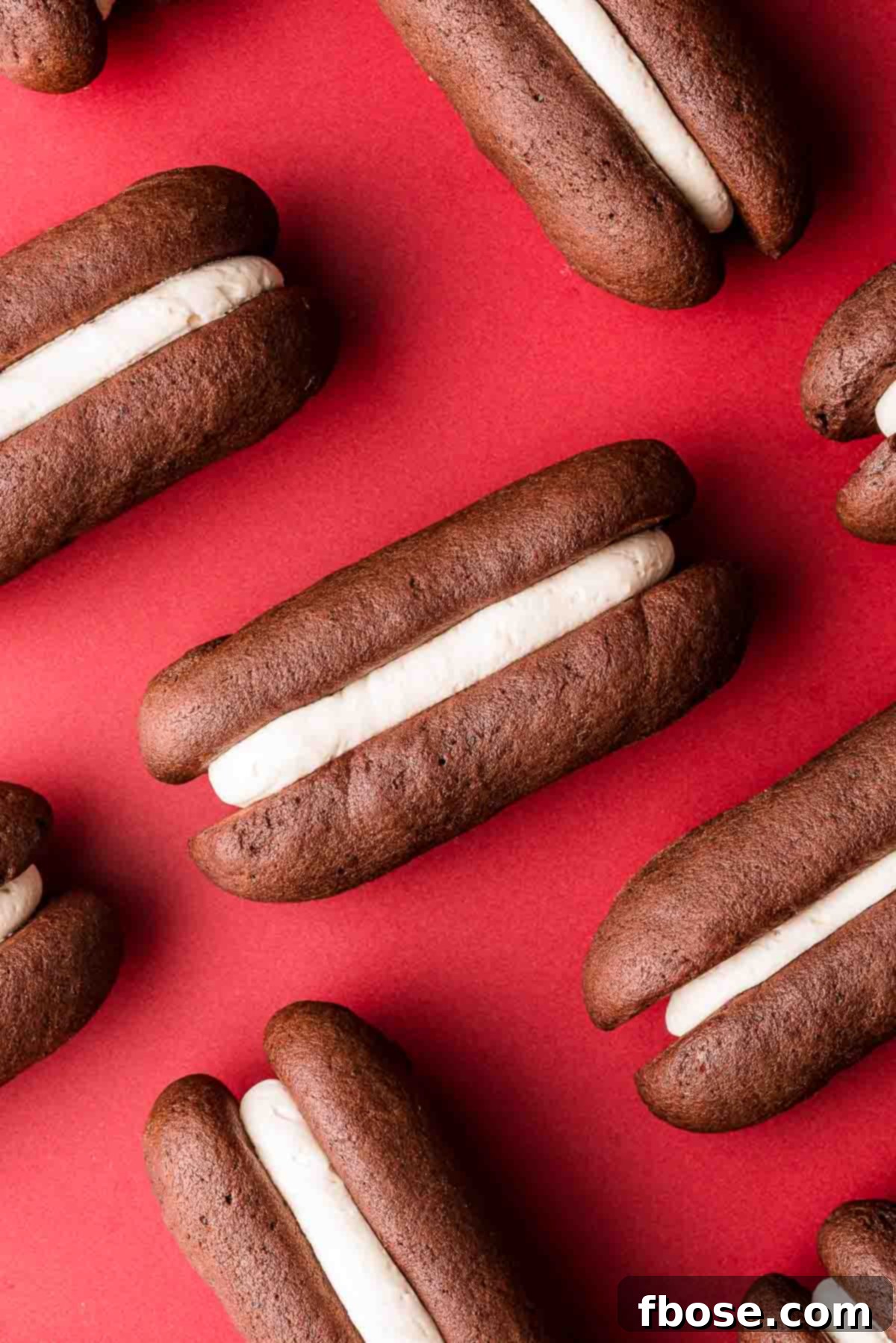 Homemade devil dogs on a red surface.