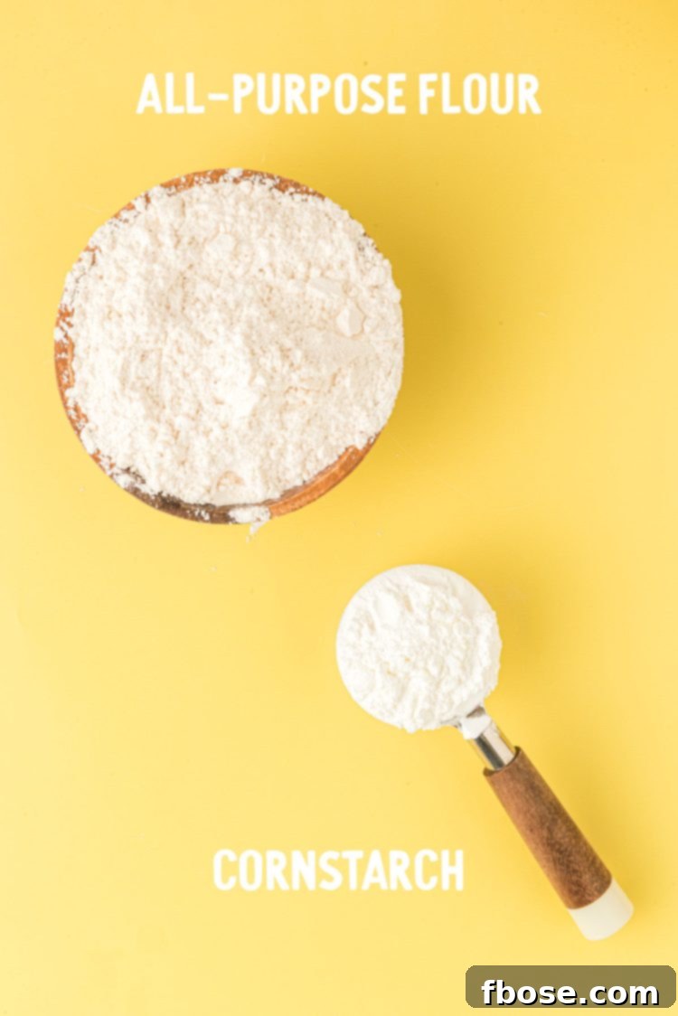 Two key ingredients for homemade cake flour: a bag of all-purpose flour and a container of cornstarch, laid out on a yellow surface.
