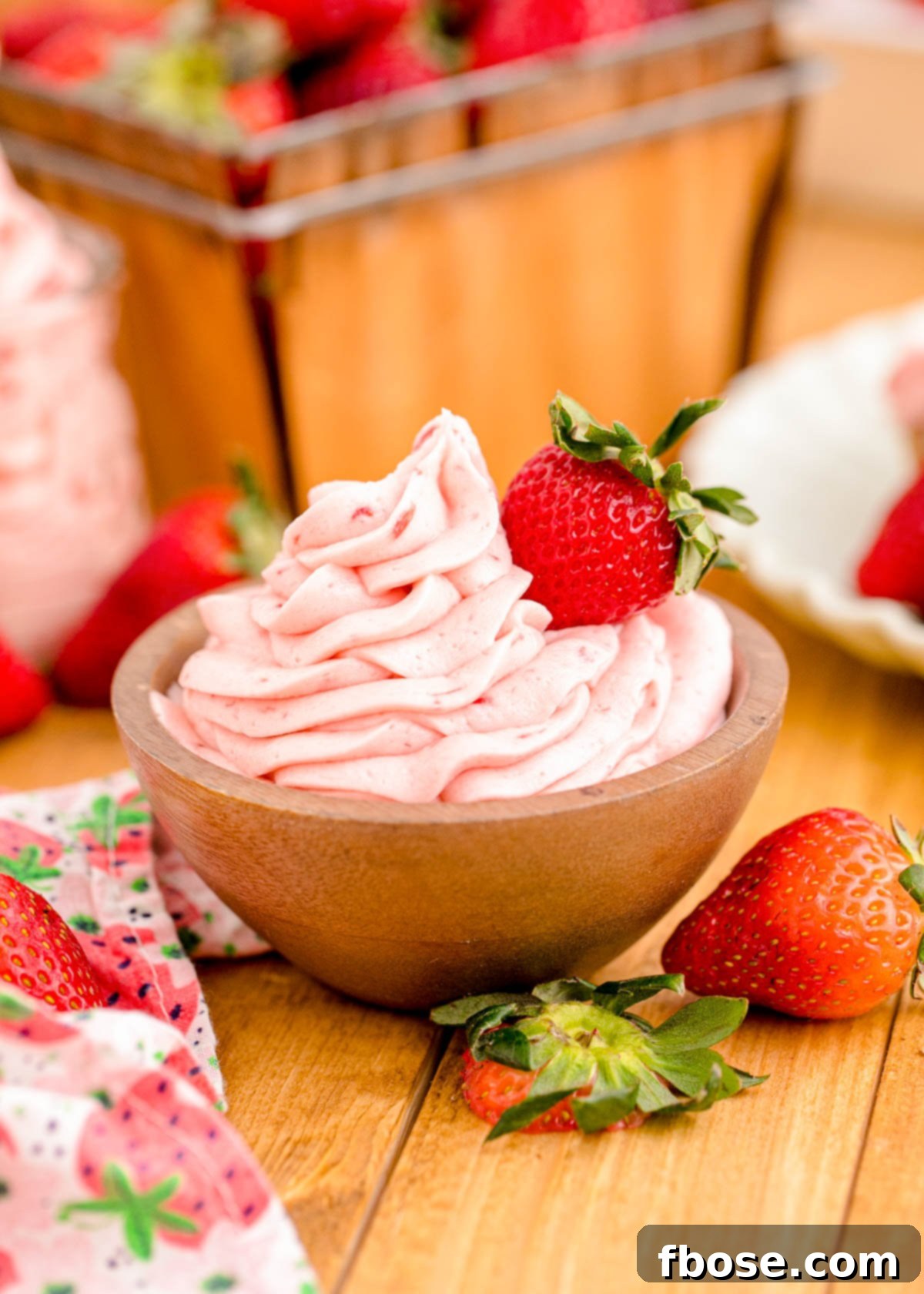Strawberry buttercream frosting in a wooden bowl.