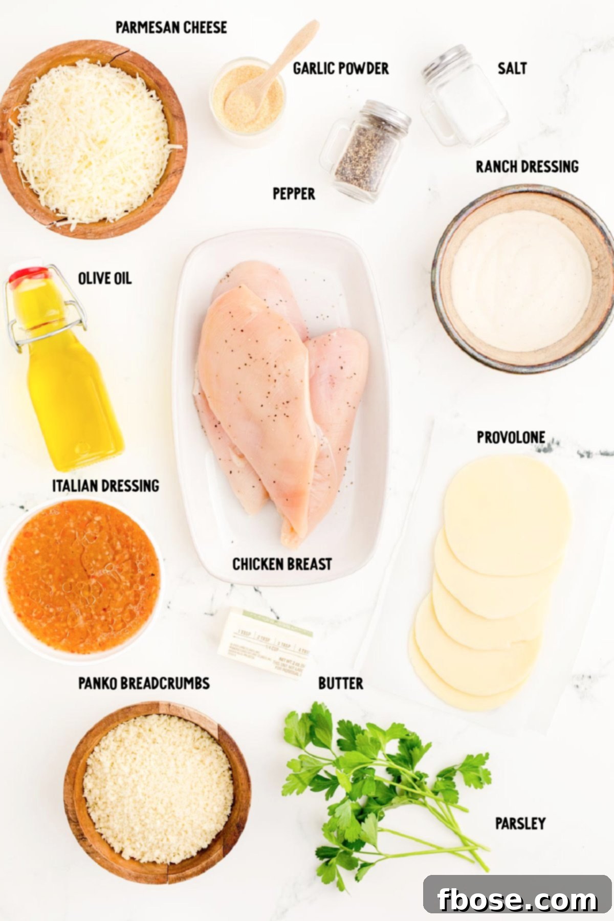 Ingredients to make parmesan crusted chicken on a marble counter.