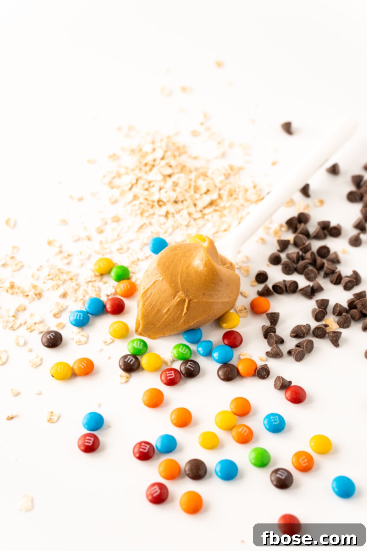 A colorful array of M&Ms and chocolate chips waiting to be mixed into the dough.