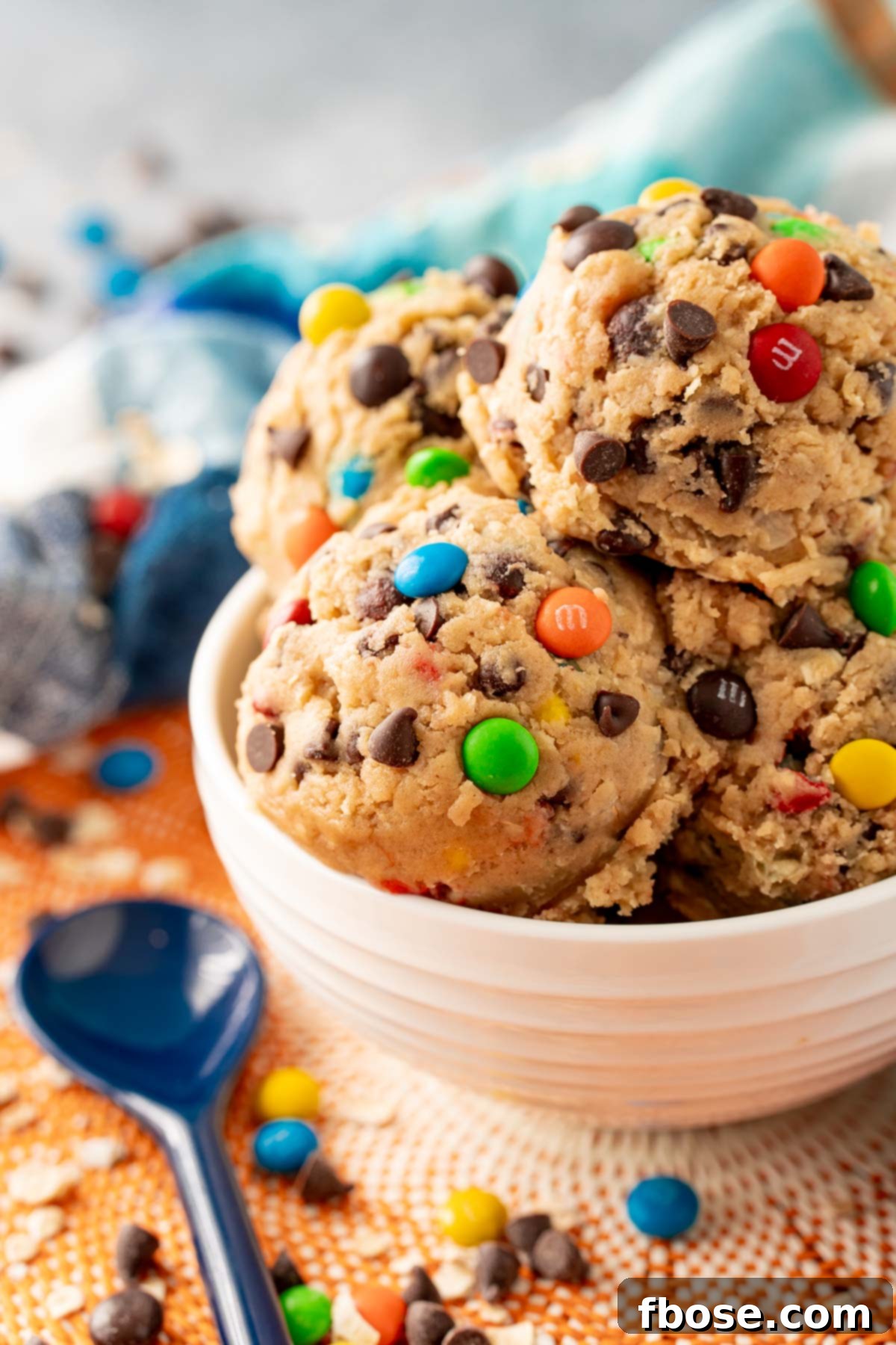 Close up of a white bowl filled with scoops of monster cookie dough.