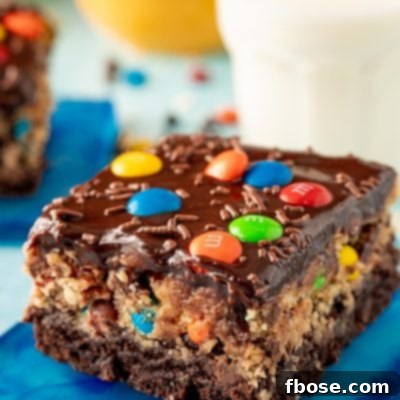 Close up of a slice of monster cookie dough brownies on a blue coaster.