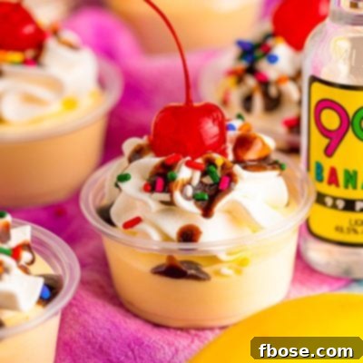 Close up photo of banana split pudding shots in plastic shot containers.