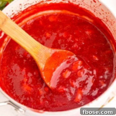 Close up photo of strawberry puree in a pot, demonstrating its rich texture.