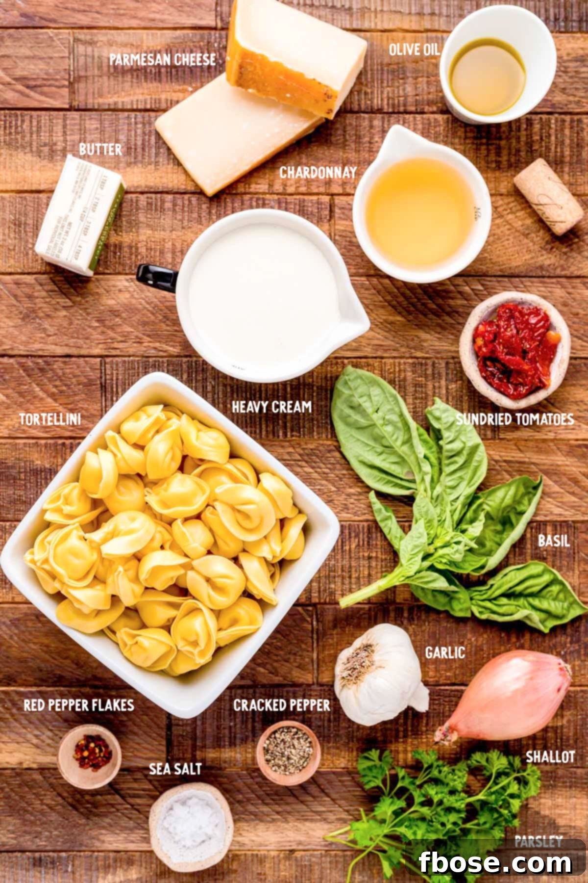 A vibrant array of fresh ingredients laid out on a wooden table, ready to make tortellini alla panna.
