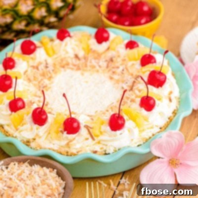 Pina colada pie in a teal pie dish on a wooden table.