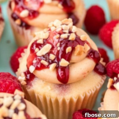 Close up of peanut butter and jelly cupcakes clustered together on a blue surface.