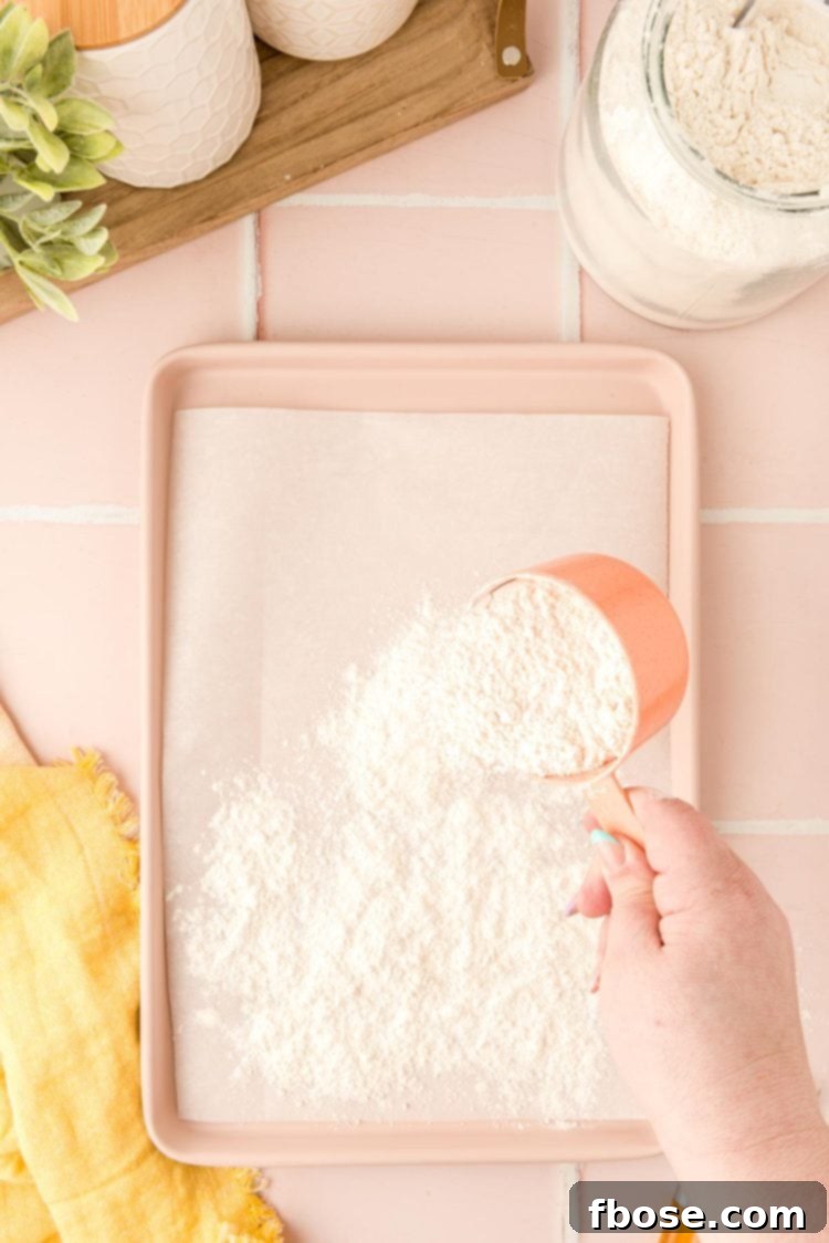 Flour being spread on a baking pan to be heat treated in the oven.