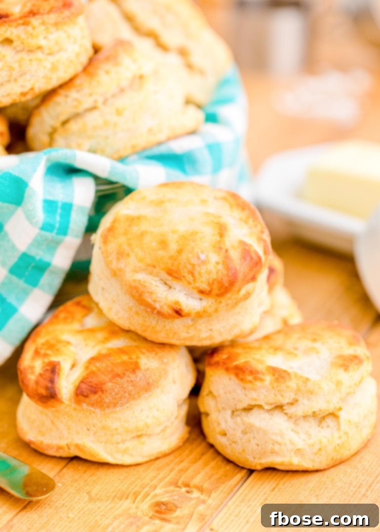 Buttermilk biscuits on a wooden table with a teal and white napkin.