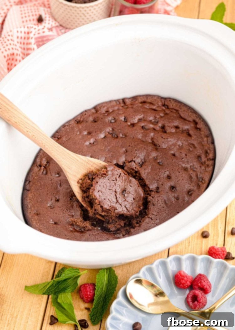 Ultimate Homemade Crockpot Chocolate Cake 4 Chocolate cake being scooped out of a white crockpot.