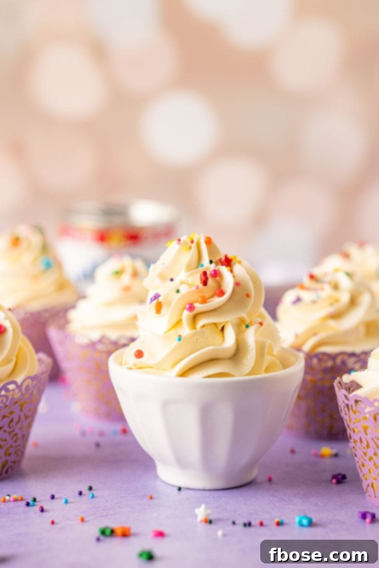 Sweetened condensed milk frosting in a white bowl with cupcakes around it.