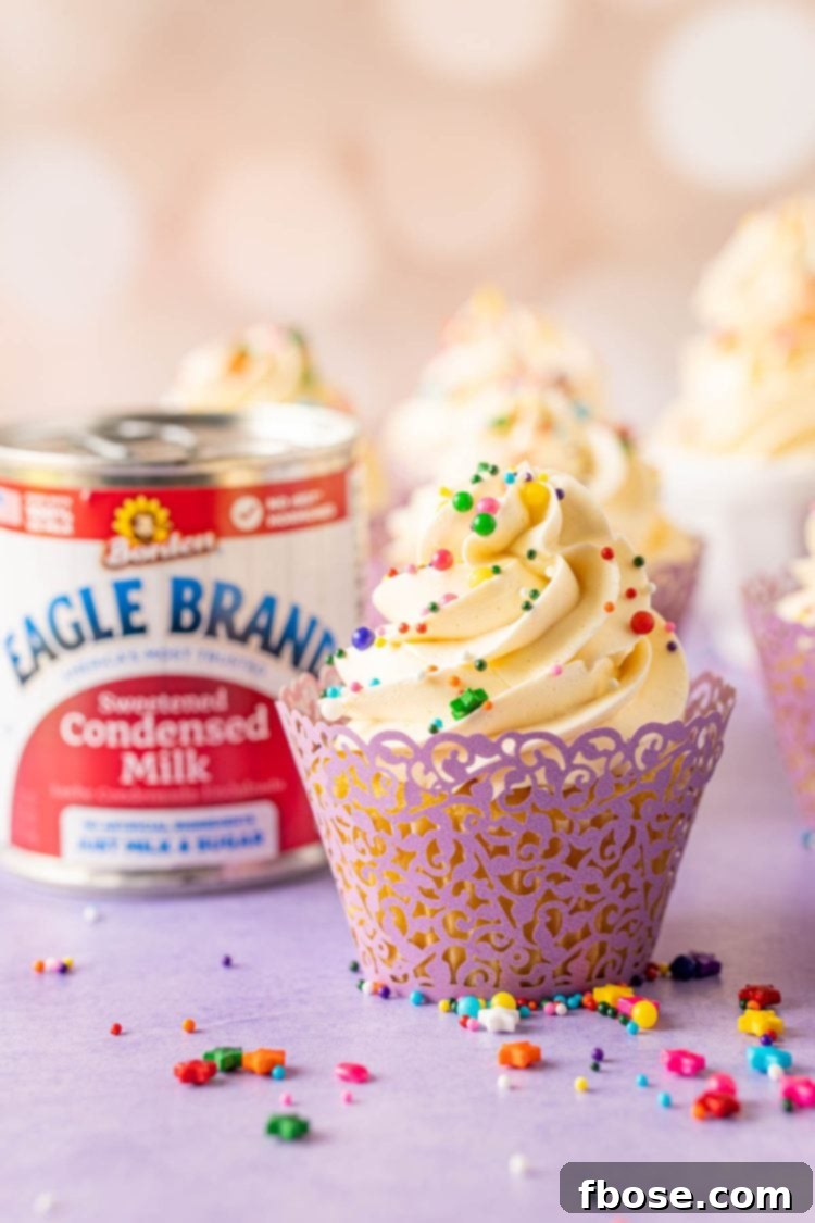 A cupcake topped with Russian buttercream on a purple surface.