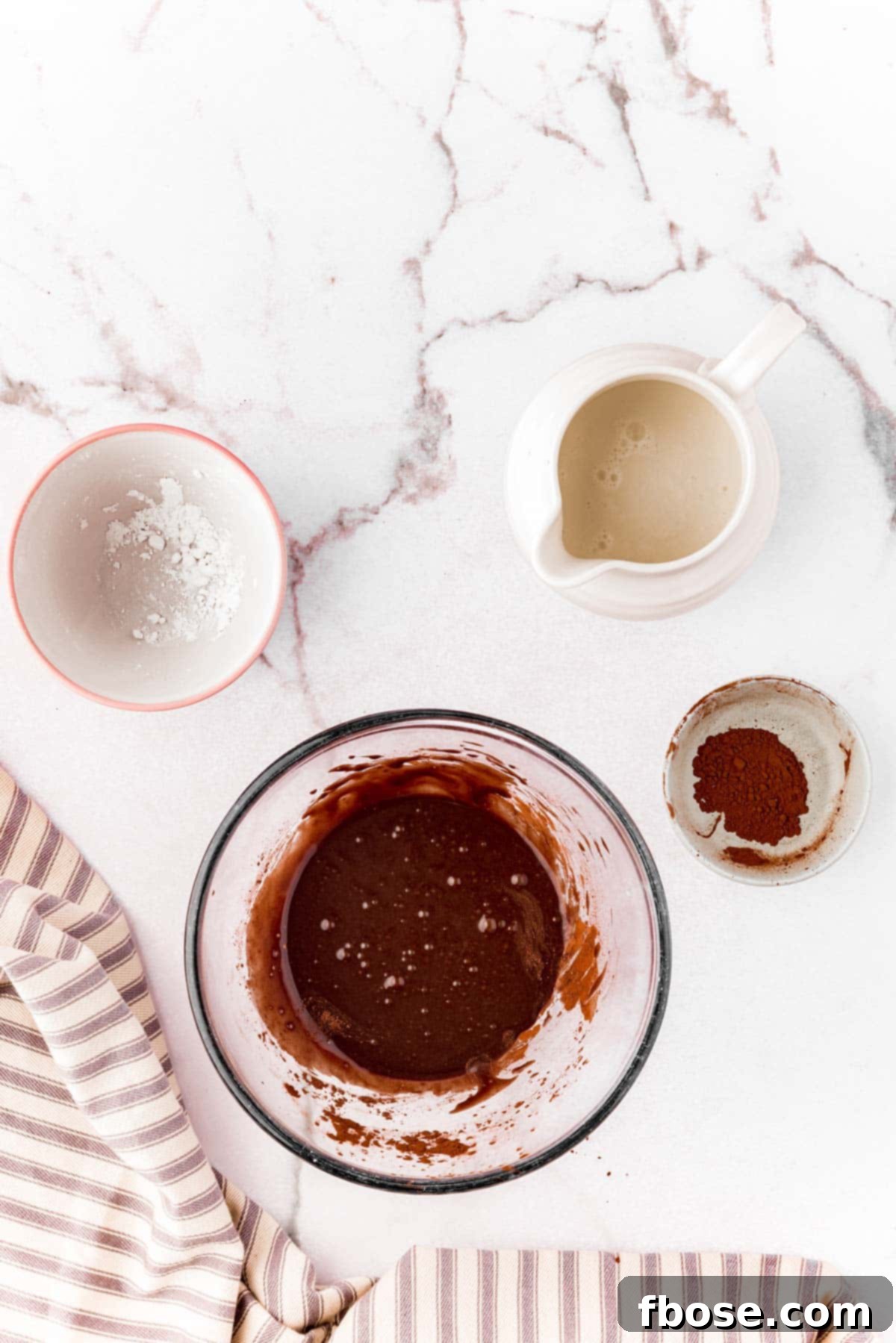 Decadent Chocolate Cinnamon Swirls 15 Chocolate glaze for cinnamon rolls prepared in a mixing bowl.