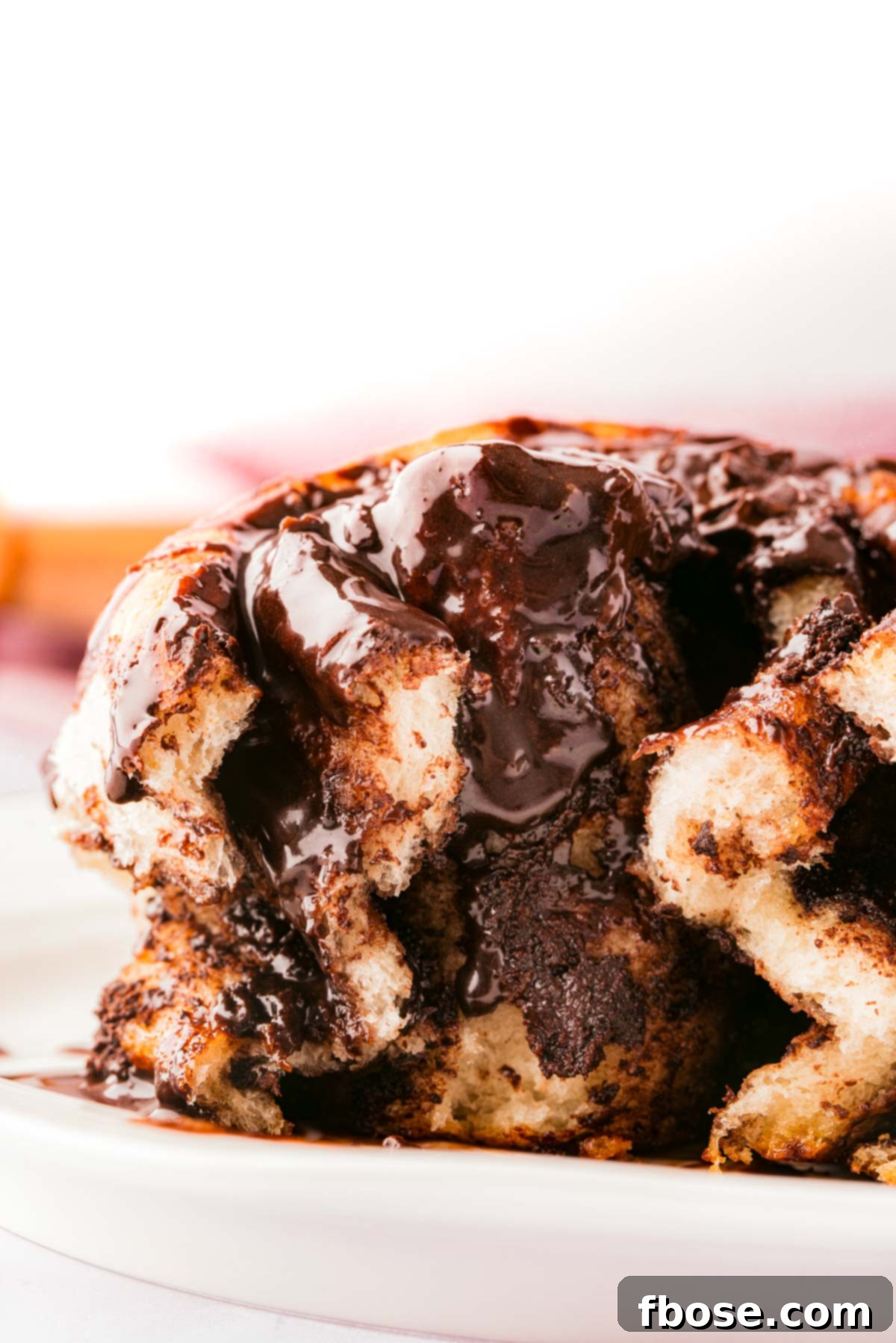 Decadent Chocolate Cinnamon Swirls 17 Chocolate cinnamon roll on a white plate showing the center.