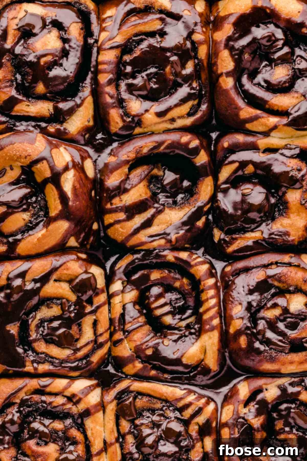 Decadent Chocolate Cinnamon Swirls 3 Overhead photo of cinnamon rolls covered in chocolate in the pan.