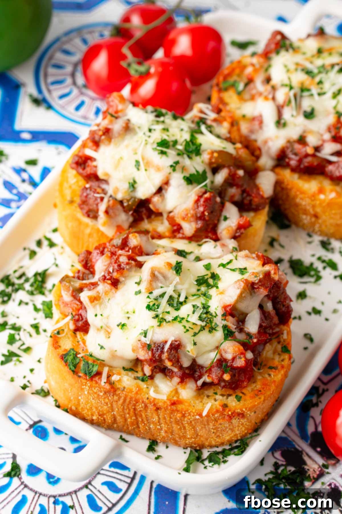 Another close-up shot of Texas toast sloppy joes, perfectly cheesy and saucy, presented on a white plate.