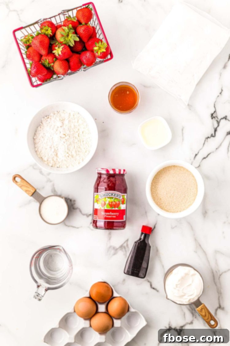 Ingredients to make strawberry shortcake cupcakes on a marble surface.
