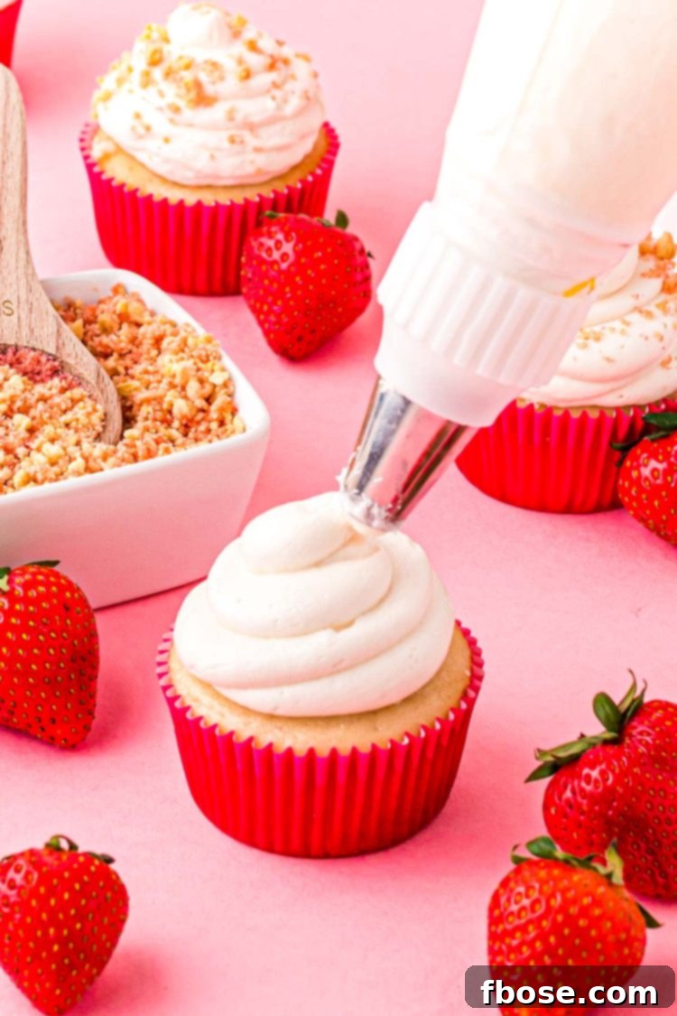Frosting being piped on a cupcakes.