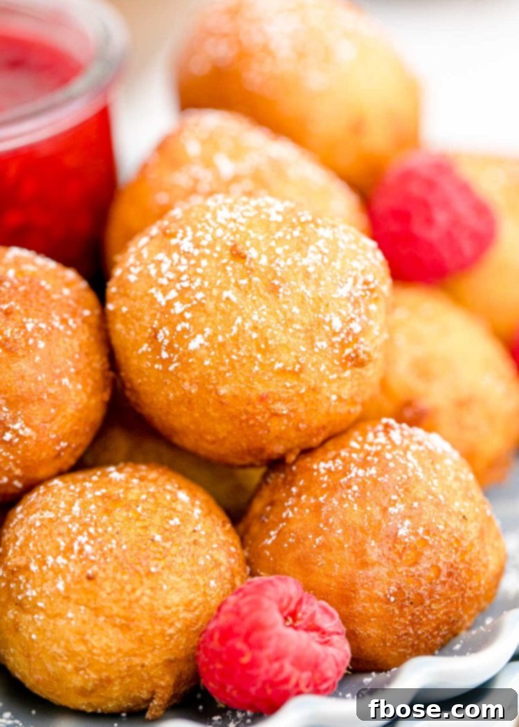 Close up of fried cheesecake balls with raspberries.