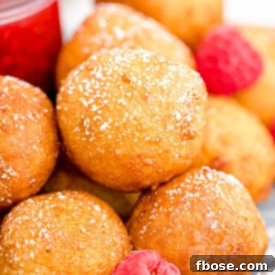 Close up of fried cheesecake balls with raspberries.