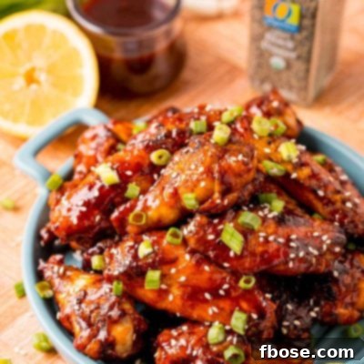 Sticky Korean BBQ Chicken Wings 11 Close up photo of grilled Korean BBQ chicken wings on a blue serving plate.