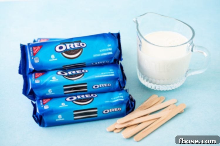 Ingredients to make Oreo popsicles on a blue surface.