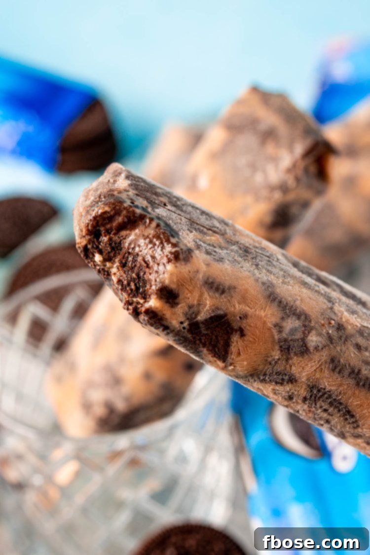 An Oreo popsicle with a bite missing from it.
