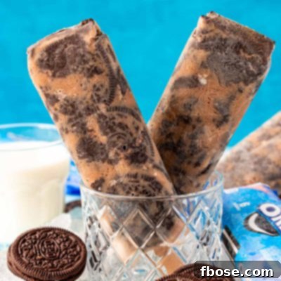 Close up photo of two Oreo popsicles in a glass with ice and oreos around it.