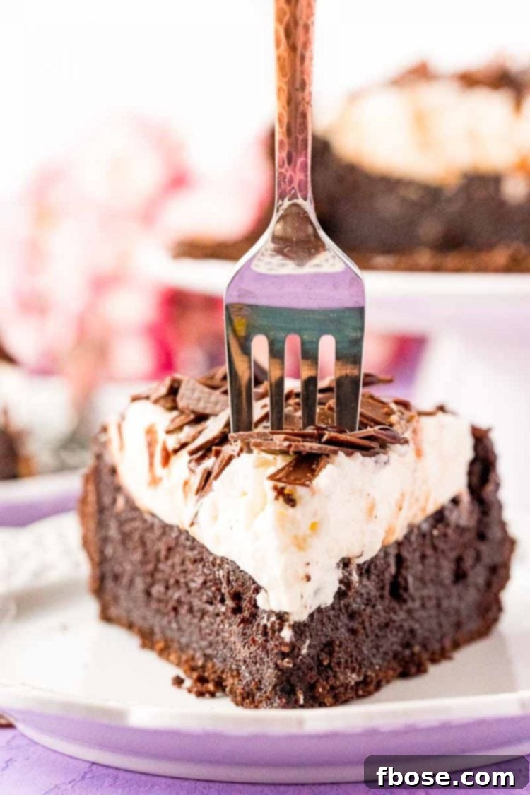 close up photo of a slice of Mississippi Mud Pie with a fork getting ready to take a bite out of it, emphasizing its deliciousness and inviting texture.