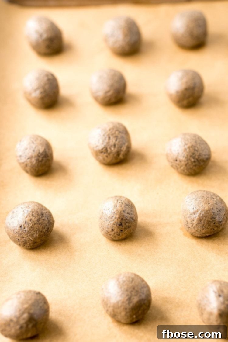 Peanut butter Oreo balls on a piece of parchment paper ready to be dipped in chocolate.
