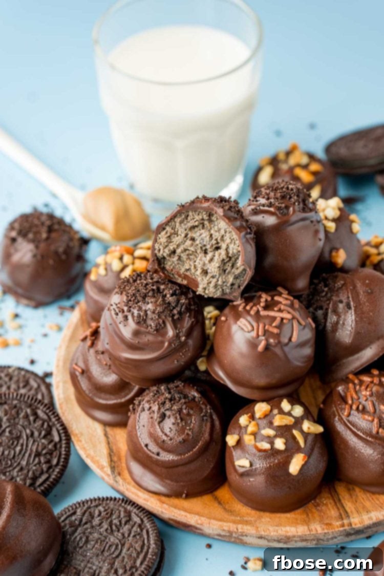 Close up of peanut butter oreo balls stacked on a wooden plate.