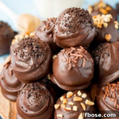 Close up of peanut butter oreo balls stacked on a wooden plate.