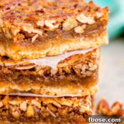 Close up photo of a stack of three pecan pie bars.