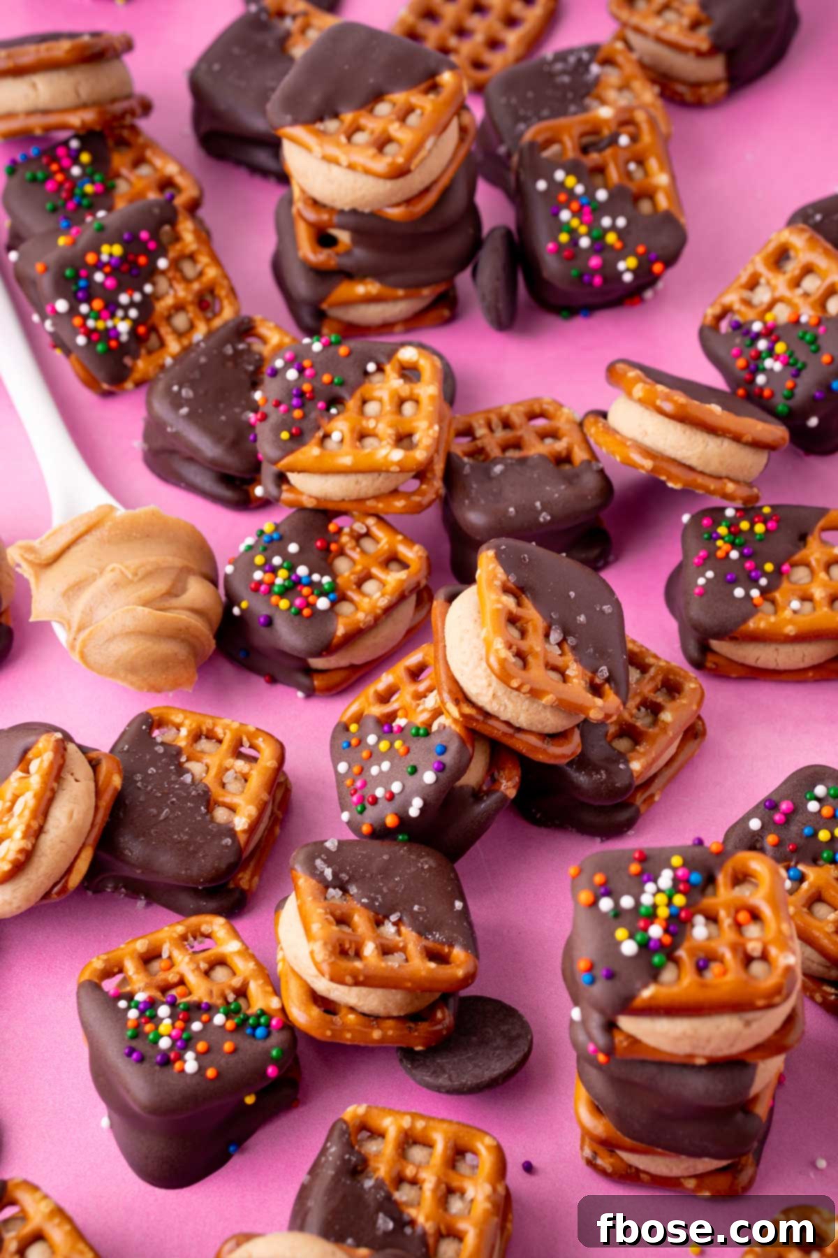 Peanut butter pretzel bites on a pink surface.