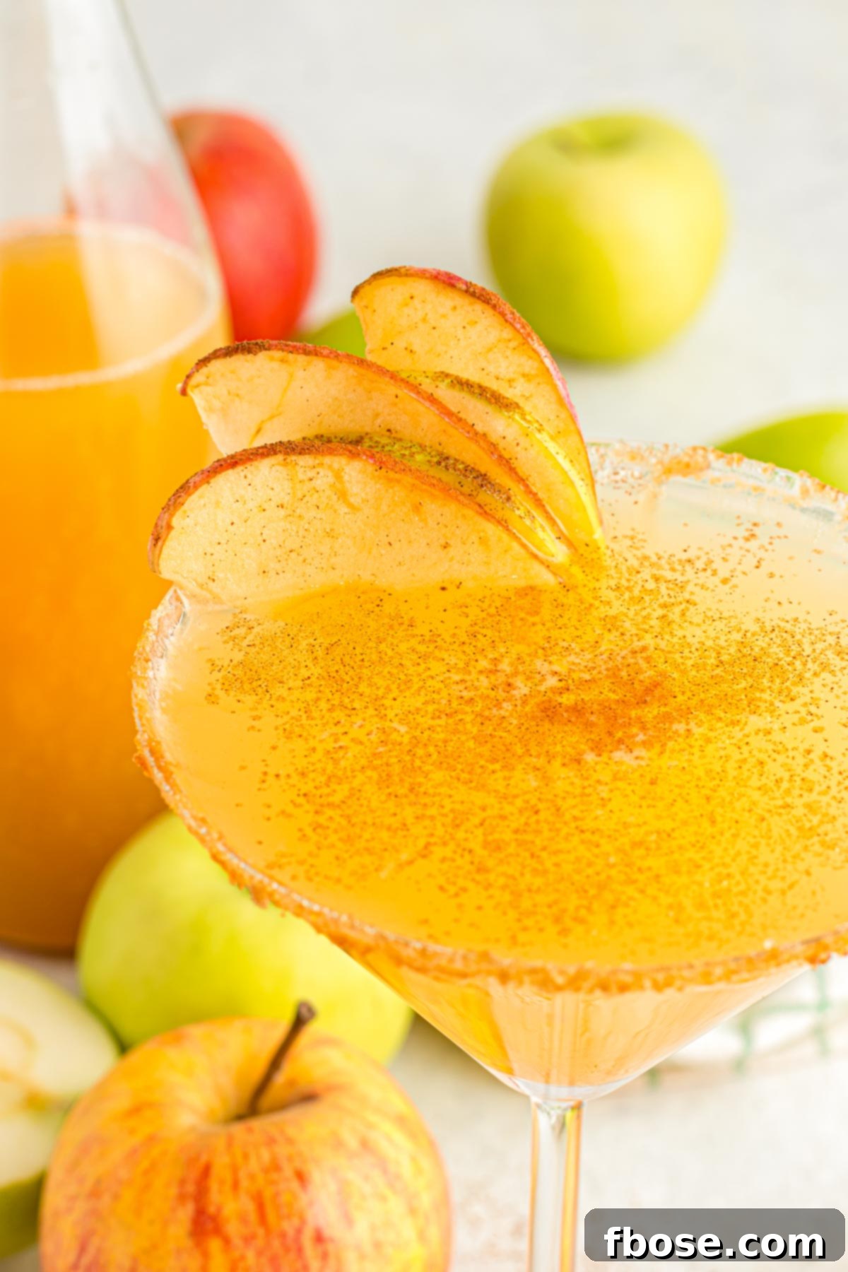A close-up shot of an elegant martini glass showcasing a vibrant apple martini, perfectly garnished and ready to be enjoyed.