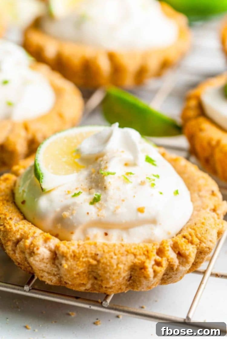 Close up photo of a Crumbl Copycat Key Lime Pie Cookie on a wire rack, showcasing its creamy filling and graham cracker crust texture.