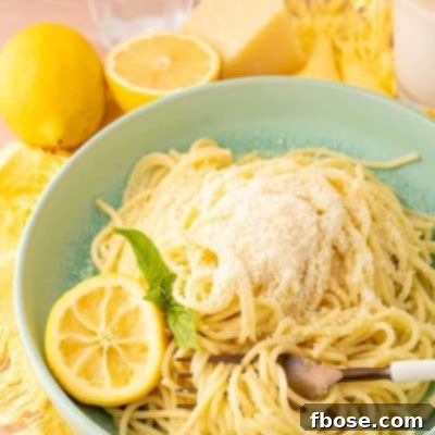 A green bowl filled with spaghetti limone on a yellow napkin, highlighting the simple yet delicious meal.
