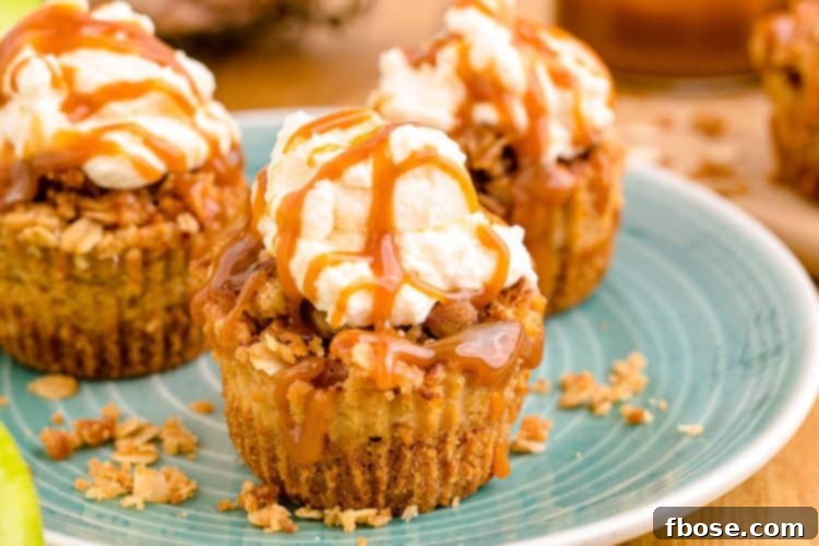 Close-up shot of mini caramel apple cheesecakes, showcasing the rich caramel drizzle and fluffy whipped cream, on a vibrant blue plate.