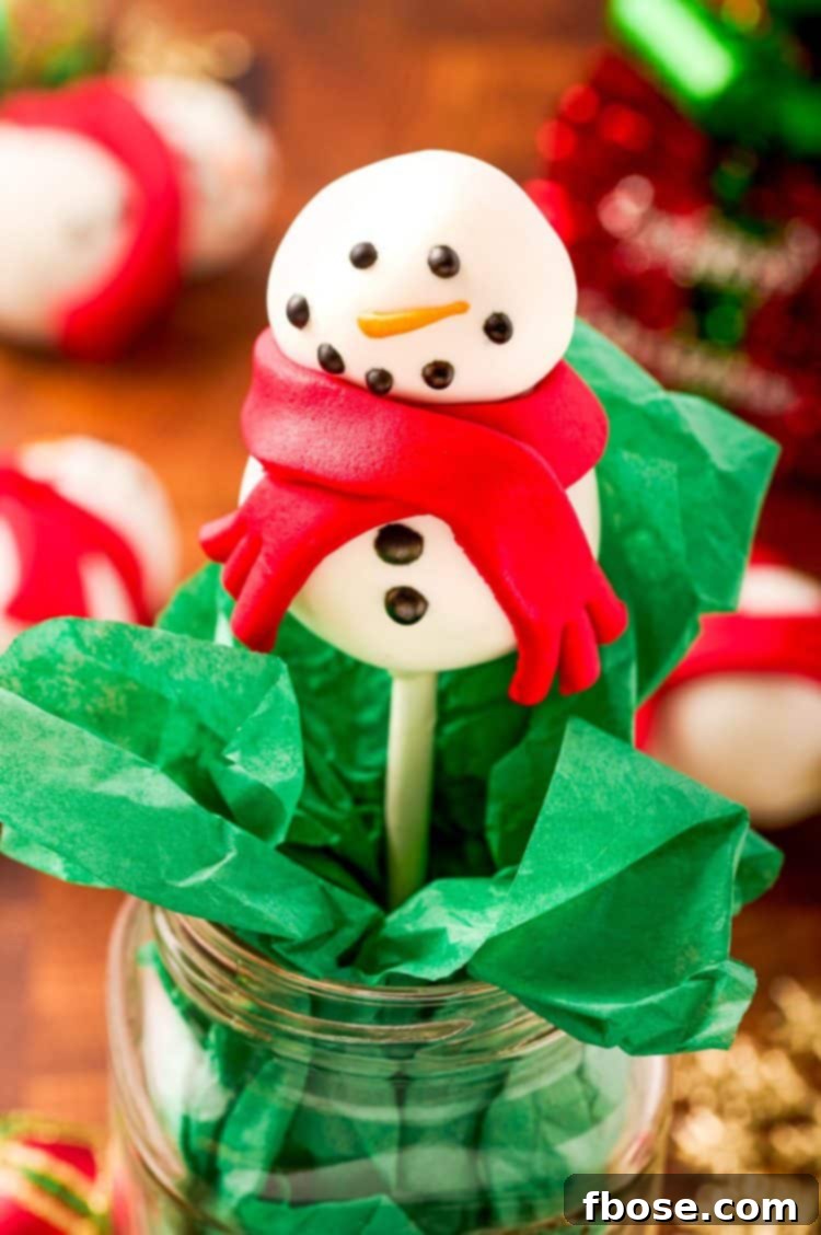 Snowman cake pop in a mason jar with green tissue paper.