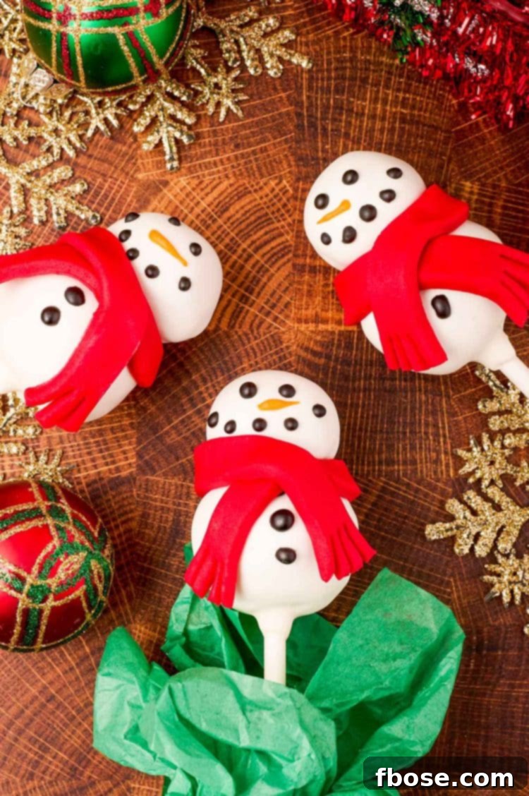 Cute snowman cake pops on a wooden table.