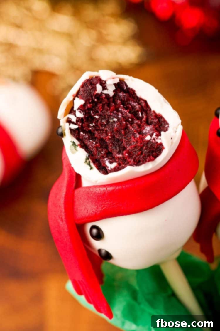 Snowman cake pop with a bite in it to reveal the red velvet center.